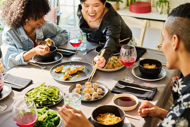 People sharing dumplings, edamame and fried rice at a table